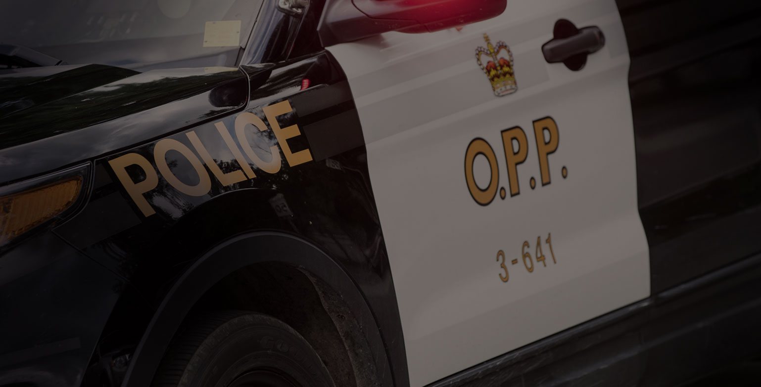 Close up of the left side of an Ontario Police car with the O.P.P logo of a crown
