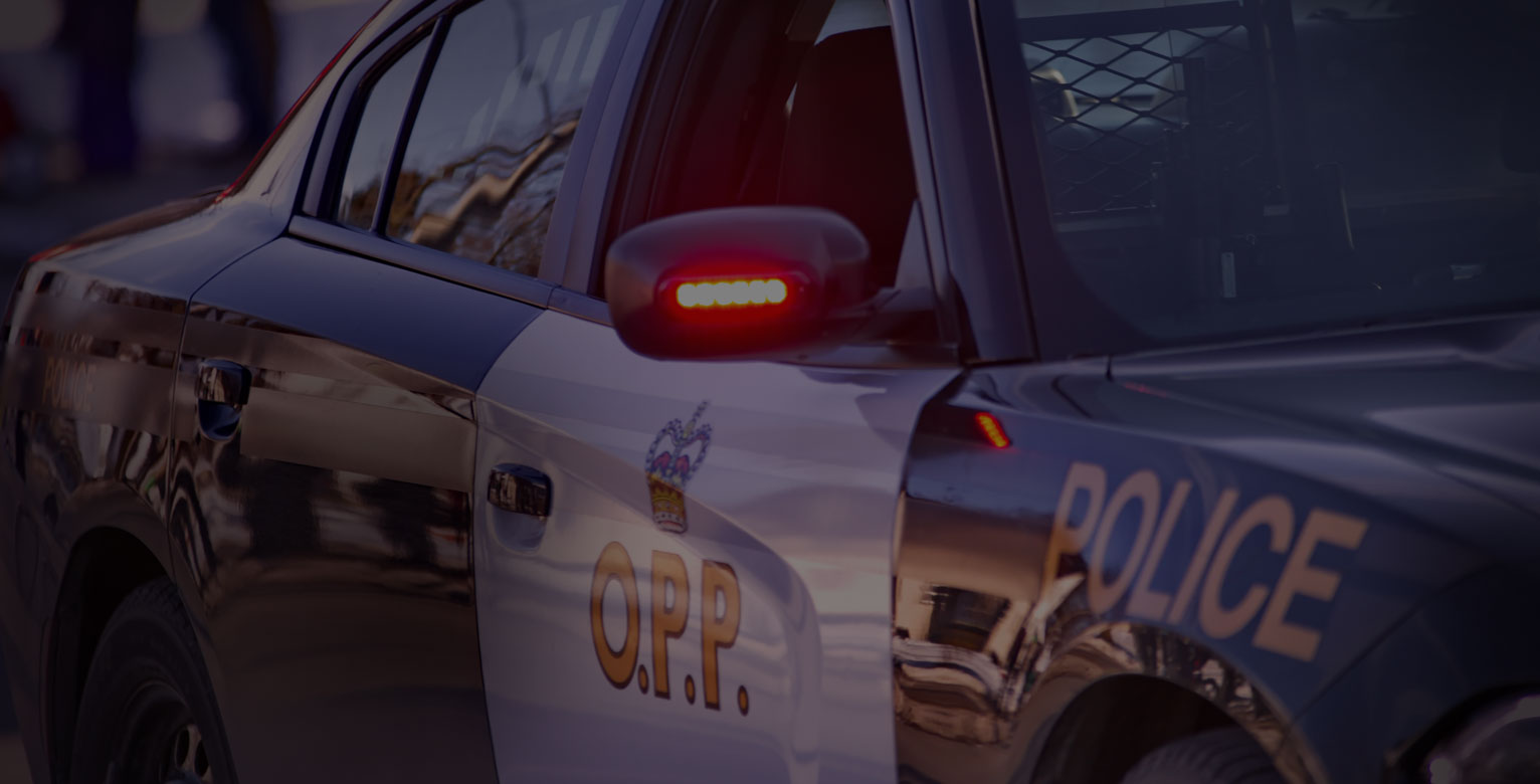 Close up of the side of an Ontario Police Car with its side mirror light on